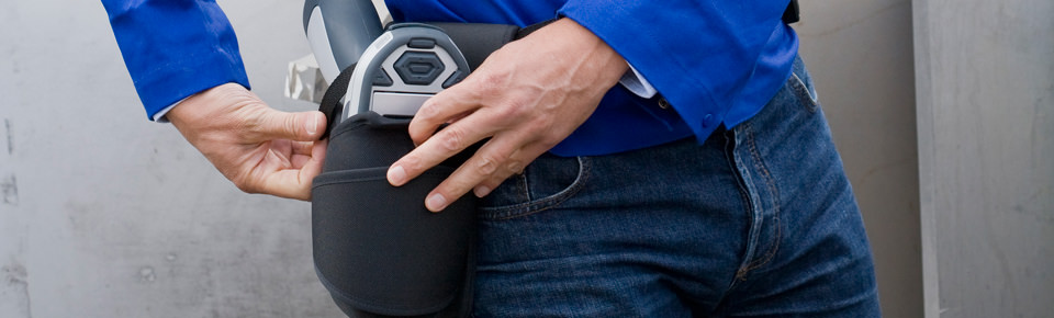 Man fastens his mobile XRF analyzer in the holster.